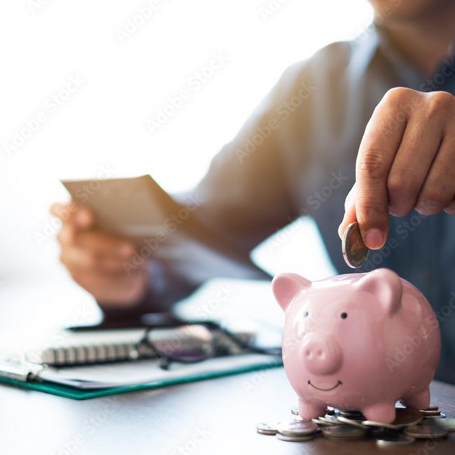 Close-up image of man hand putting coins in pink piggy bank for account save money. Planning step up, saving money for future plan, retirement fund. Business investment-finance accounting concept.